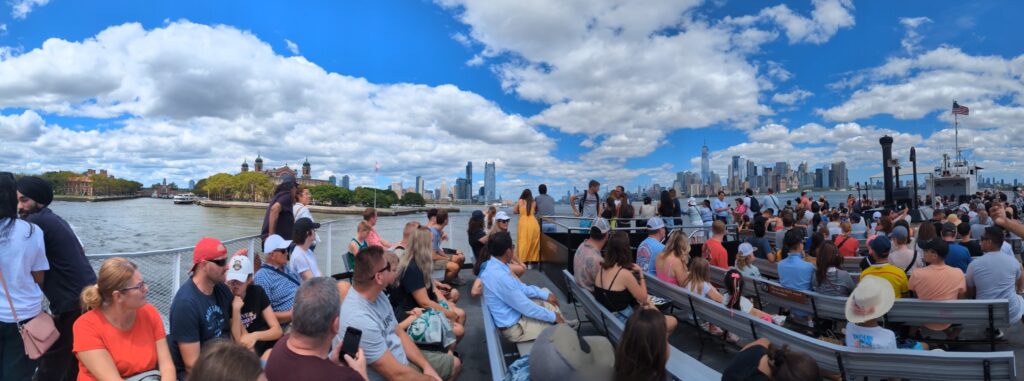 Panorama.  NYC Tourists on Statue of LIiberty Ferry